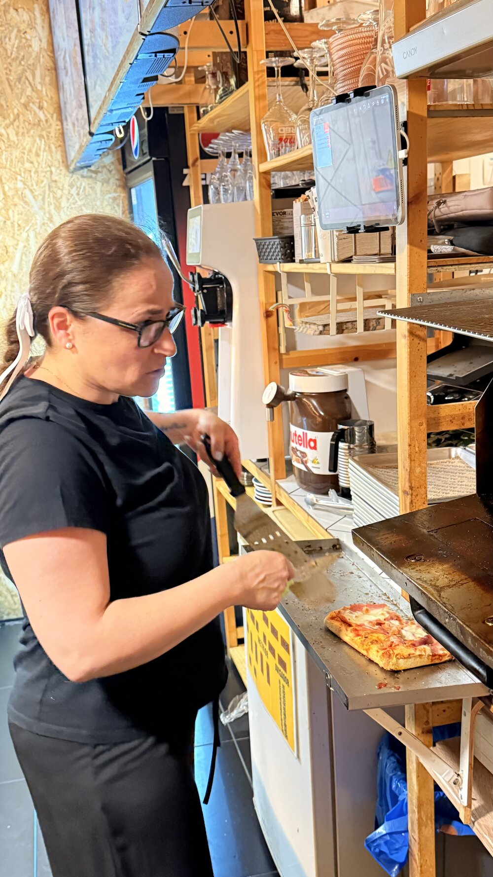 Isa, kitchen team member at Altaglio, heating up a pizza