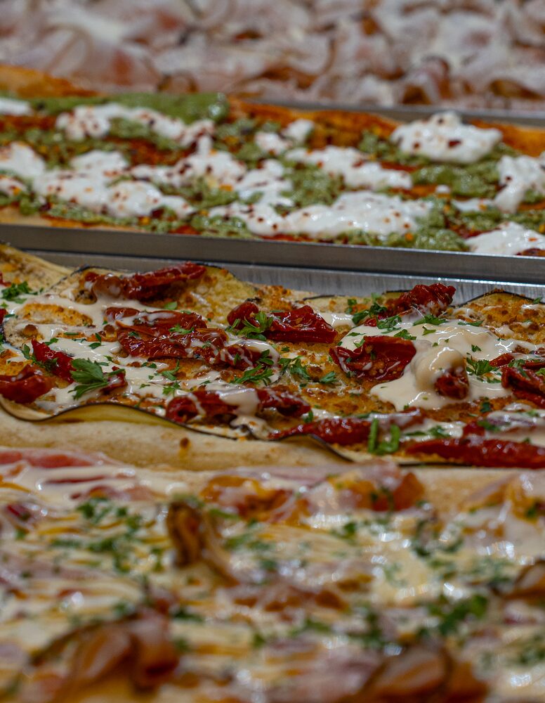 Pizza Burrata al corte: tomate, burrata, pesto y peperoncino